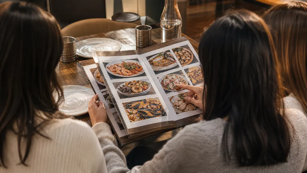 Nhóm bạn xem thực đơn buffet hải sản trước khi chọn món